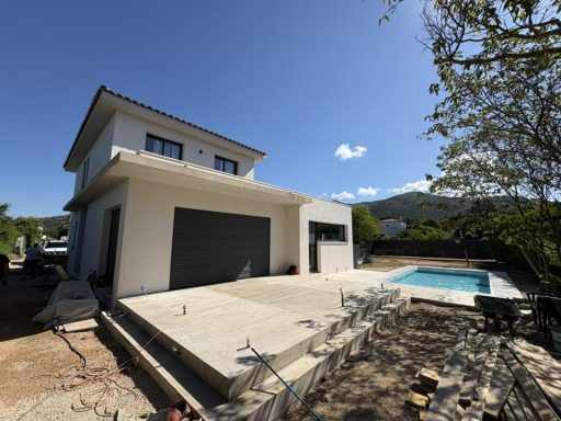 Réalisation d’une dalle béton en pourtour de piscine, un projet clé pour une finition soignée et durable. Maison moderne avec piscine, terrasse et jardin, sous un ciel bleu ensoleillé.