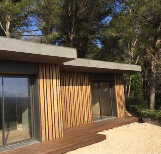 Construction maison POPUP Maison moderne en bois avec de grandes fenêtres, construite dans un environnement naturel.