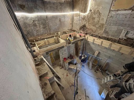 Création d’un 3eme niveau en sous sol dans une maison de ville au Roucas-Blanc Chantier de construction avec des ouvriers et des structures en bois.
