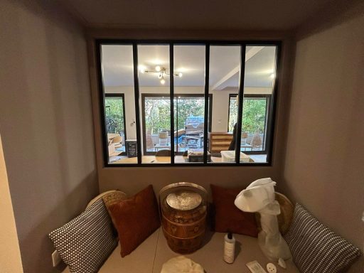 Rénovation totale d'un appartement Espace de vie lumineux avec un coin salon et une vue sur le jardin à travers une fenêtre.